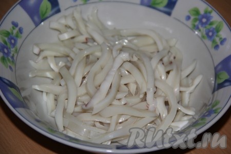 Вареных кальмаров нарезать на длинные полоски.
