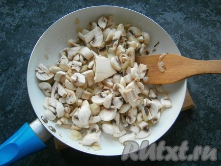 Обжарить лук на среднем огне, помешивая, около 3-4 минут, после чего добавить нарезанные средними кусочками шампиньоны и 20-25 грамм сливочного масла.
