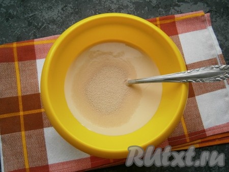 Ряженку можно взять любой жирности. Я купила жирностью 4%. В достаточно объёмную миску влить чуть тёплую ряженку (я её подогрела буквально в течение 20 секунд в микроволновке), всыпать дрожжи, добавить сахар.