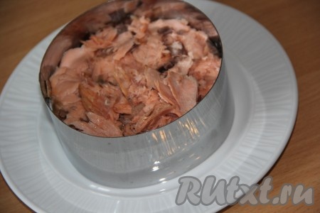 Горбушу горячего копчения предварительно очистить от косточек, порвать филе на волокна. Поверх слоя картофеля выложить слой рыбы.
