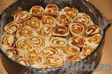 Затем выложить в один слой рулетики с курагой. Выкладывать не слишком плотно.
