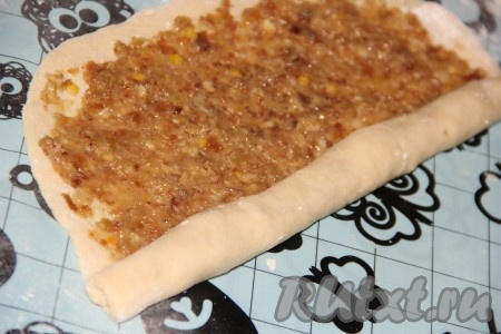 Свернуть тесто с начинкой в плотный рулет. У нас получится 4 рулета с курагой и 4 рулета с изюмом и орехами.
