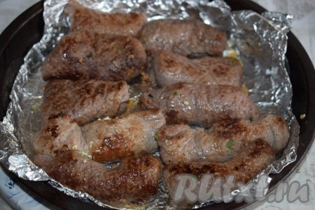 Форму для запекания застилаем фольгой и выкладываем в нее обжаренные рулетики, удаляя зубочистки перед запеканием.
