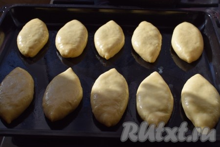 Таким образом лепим все пирожки. Одно яйцо взбиваем вилкой, добавляем 1 столовую ложку молока, перемешиваем и получившейся смесью смазываем все пирожки.
