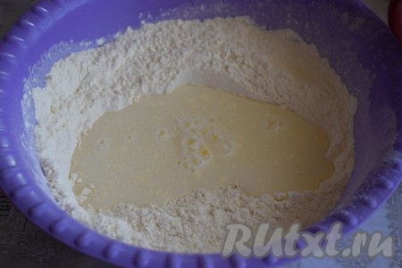 Далее приступим к приготовлению теста, для этого просеем в миску муку. Смешаем сметану с тёплой водой и добавим к муке.

