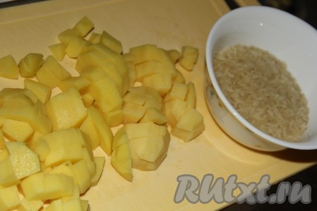 Картофель, лук и морковь очистить, рис промыть. Картошку нарезать на кубики.