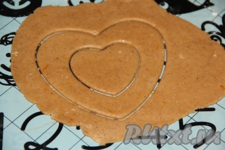 Готовое тесто разделить на несколько частей и раскатать в тонкий пласт (толщина пласта, примерно, 3-5 мм). Работать лучше с холодным тестом, в этом случае оно не стягивается и не деформируется. Поэтому пока работаете с одной частью теста, оставшееся тесто пусть лежит в холодильнике. Затем вырезать печенье любой формы. Я вырезала печенье в форме сердечек.
