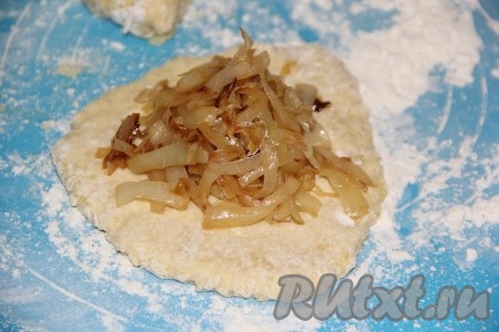 Разделить "отдохнувшее" картофельное тесто на 8 частей. На столе, посыпанном мукой, сформировать из каждой части теста лепёшку, выложить часть жареной капусты.