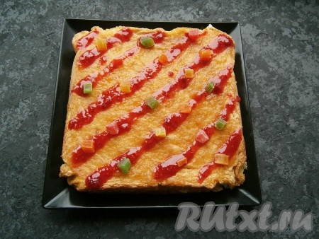 Поверх смазанной половины бисквита выложить вторую часть бисквита, верх также смазать вареньем и украсить цукатами.
