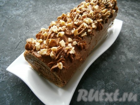 Смазать рулет сверху и по бокам оставшимся шоколадным кремом. Можно из кулинарного мешка с помощью насадок нанести сверху на рулет любой рисунок, цветочки и т.д. Украсить шоколадный рулет любыми орешками.&nbsp;
