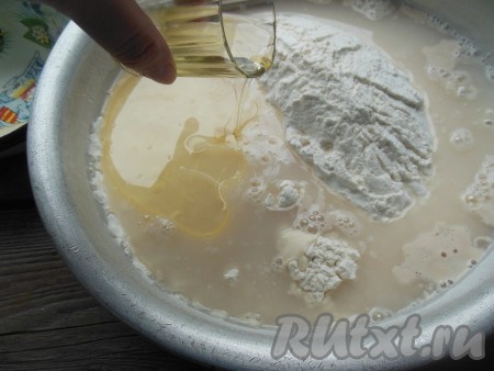 В миску с мукой добавьте дрожжевую смесь, смесь воды и соли, 80 мл растительного масла.
