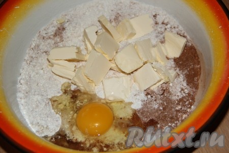 Слегка перемешать сухие ингредиенты. Затем добавить кусочки мягкого масла и яйцо.