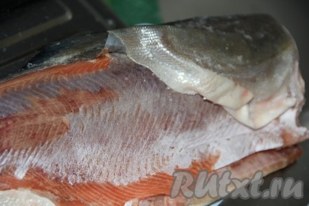 Отрезать голову и хвост горбуши. Снять шкурку. Если рыба не полностью разморожена, то шкурка снимается ровно (чулком). Голову и хвост можно использовать для приготовления домашней ухи.
