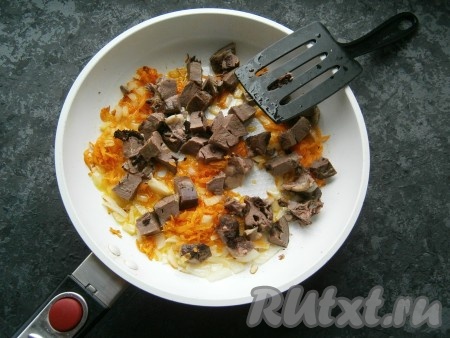 Обжарить лук с морковью на среднем огне до мягкости, затем добавить нарезанное свиное сердце. Обжаривать, помешивая, на среднем огне около 4-5 минут.
