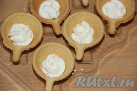 Отсадить небольшое количество сыра на дно тарталетки.