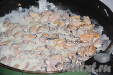 Когда вся жидкость из мидий выпарится, выложить к ним смесь сметаны и чеснока, перемешать. Томить мидии в сметане на медленном огне, примерно, 5-7 минут.
