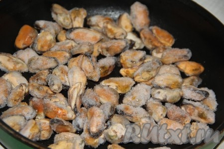 Я использовала замороженные мидии, предварительно их не размораживала. Выложить замороженные мидии в сковороду и начать тушить на среднем огне.
