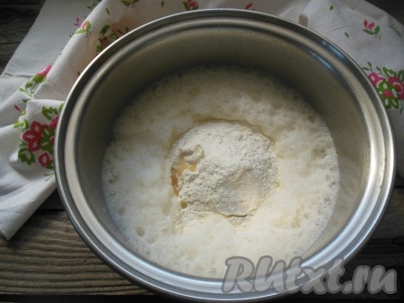 Влейте 2 столовых ложки растительного масла, всыпьте часть просеянной муки, перемешайте на небольших оборотах миксера (или венчиком) до однородности.