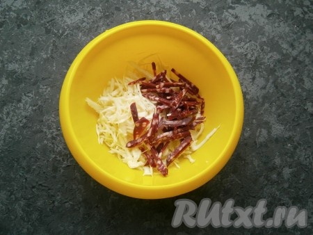 Капусту тоненько нашинковать, добавить чуточку соли, помять капусту руками. Добавить нарезанную тонкой соломкой копченую колбасу.