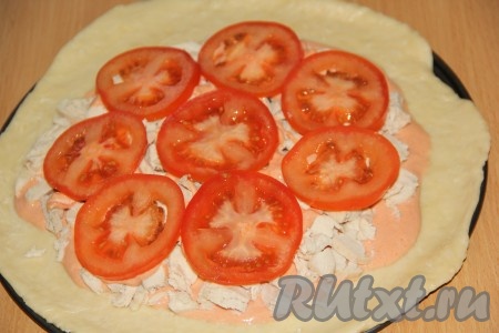Помидор вымыть, нарезать на тонкие кружочки, выложить поверх курицы.