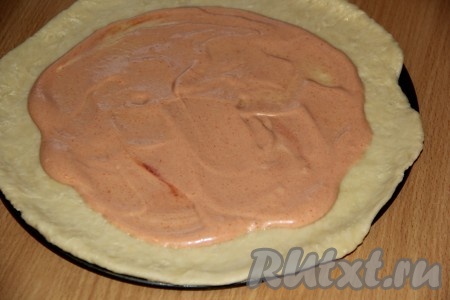 Тесто достать из холодильника и раскатать в круг (не очень тонко). Раскатанное тесто выложить на противень (или в форму), предварительно смазанный маслом или застеленный пергаментом. Смазать соусом из майонеза и кетчупа середину круга, оставляя края теста чистыми (немного соуса оставьте для смазывания начинки).