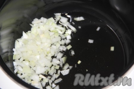 Лук и морковь очистить. В чашу мультиварки влить растительное масло, выложить мелко нарезанный лук и обжарить его на режиме "Жарка" в течение 5 минут, периодически помешивая.
