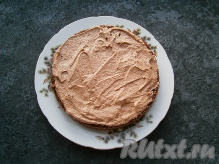 Шоколадным кремом смазать все части бисквита, сложить их друг на друга. Бока и верх шоколадного торта также смазать кремом (немного крема оставить для украшения).
