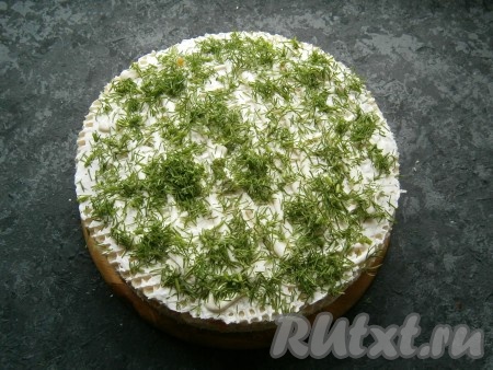 Затем все слои повторить с использованием еще трех коржей. Последний корж выложить сверху, смазать его майонезом и посыпать измельченным укропом.
