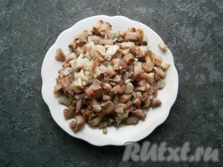 Нарезать филе сельди мелкими кусочками, тщательно удаляя все косточки.
