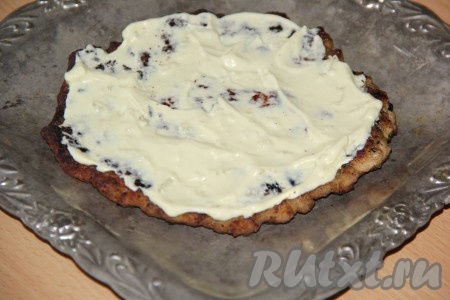 Собрать закусочный торт. Выложить мясной корж на плоскую тарелку, смазать майонезом, смешанным с чесноком.
