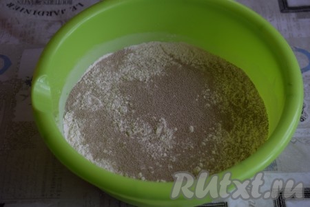 Для приготовления теста в глубокую миску просеем муку, добавим дрожжи и перемешаем до однородности.
