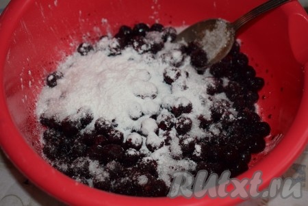 Пока тесто подходит, займемся начинкой. Для этого пирога можно брать как свежую, так и замороженную чёрную смородину. Я готовила пирог с замороженной смородиной. Для этого разморозим ягоды при комнатной температуре (или оставим на ночь в холодильнике), образовавшийся сок сольем. К ягодам чёрной смородины добавим сахар и крахмал, перемешаем.