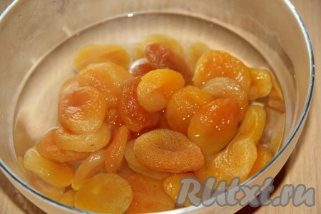 В другую миску выложить курагу, полностью залить её кипятком и оставить на 5 минут, затем откинуть на дуршлаг, лишней жидкости дать стечь.