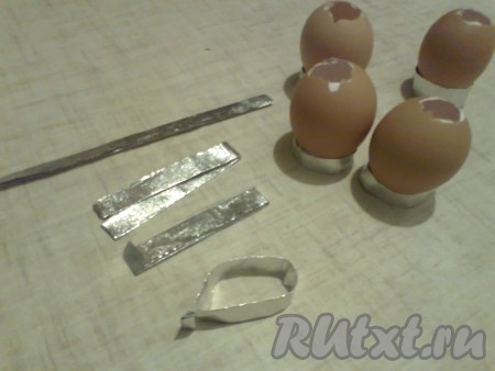 Установить скорлупки можно в небольшие формочки или приготовить для них подставки из фольги. Подставку из фольги можно сделать так: фольгу (можно от шоколадки), загибаем&nbsp;2 раза, нам нужна полоска шириной 1-2 см, длиной около 13-15 см, отрезаем, сгибаем пополам, свободные края заворачиваем вместе и подставка для скорлупы готова.
