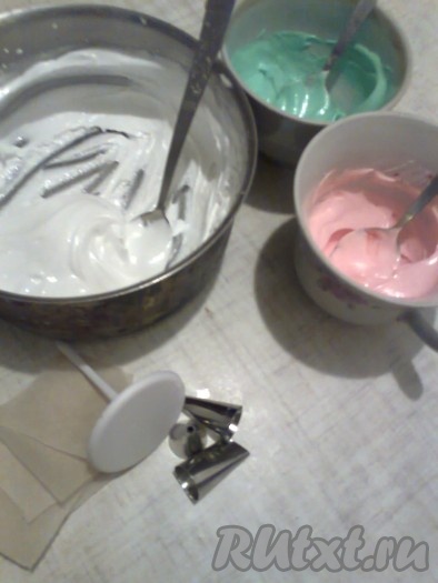 Делим получившуюся белковую глазурь на 3 части. Одну часть белой глазури оставляем без изменений. А в две оставшиеся части добавляем по одной капле красного и зеленого гелиевого красителя.
