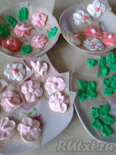 Перемешиваем глазурь и отсаживаем на пергамент с помощью кондитерского мешка и насадки (у меня насадка вилтон номер 101-лепесток розы и маленькая насадка для листиков) цветочки и листики. Для нежно-розовых цветочков смешала немножко красной и много белой глазури. Такие цветочки и листики также можно использовать для украшения куличей. Даем подсохнуть 12-24 часа при комнатной температуре.