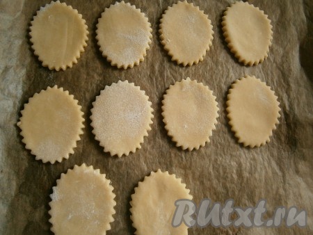 Затем песочное тесто раскатать в пласт толщиной, примерно, 0,5 см, и вырезать с помощью формочек печенье любой формы. Противень для выпечки застелить пергаментом, выложить печенье, вырезанное из теста.
