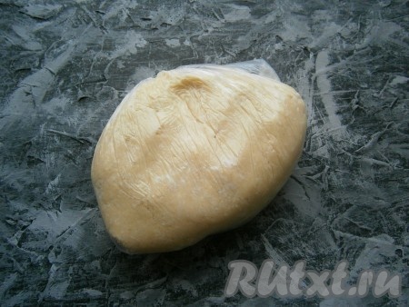 Теперь масляную массу выложить на стол, который посыпать оставшейся мукой, и замесить плотное, но достаточно мягкое тесто. Завернуть тесто в пленку и поместить в холодильник на 1 час.
