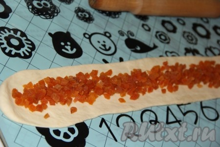 Курагу предварительно обдать кипятком, а затем нарезать на маленькие кусочки. На первую полоску выложить курагу (как на фото)
