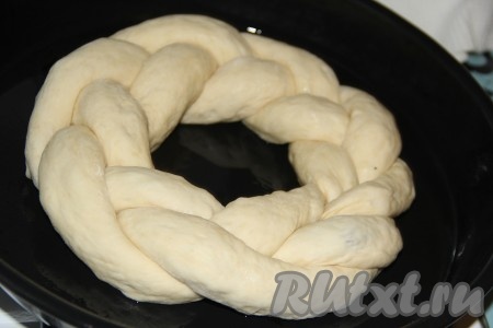 Противень для выпекания смазать растительным маслом. Выложить косу на противень и сформировать венок, хорошо скрепить края.
