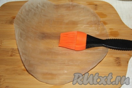 Я готовила рулетики на бамбуковой доске (можно готовить и на силиконовом коврике). Кисточкой смазать лист рисовой бумаги тёплой водой с двух сторон (температура воды, примерно, 50 градусов). Делать это нужно быстро, так как лист начинает размокать и потом будет трудно завернуть в него начинку.