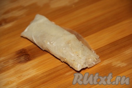 Завернуть начинку в рисовую бумагу и сформировать плотный рулетик. Аналогично сформировать оставшиеся рулетики.
