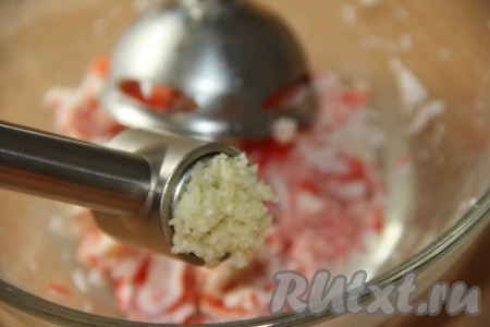 Крабовые палочки пробить погружным блендером. В получившуюся массу добавить пропущенный через пресс чеснок.
