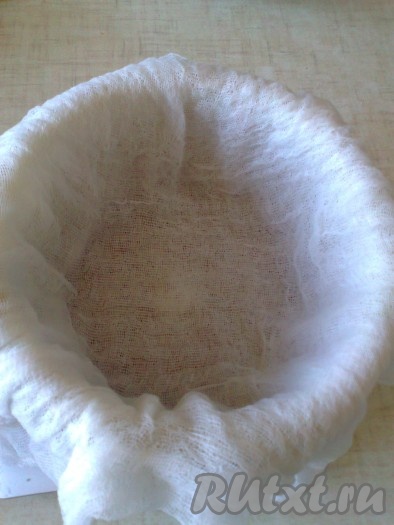 Перемешать смесь белого шоколада, масла и творожной массы. Форму для пасхи (дуршлаг) надо выстелить влажной (смочить и отжать) чистой марлей, сложенной в 2-4 слоя, (концы марли должны свисать с формы) и установить ее в подходящую посуду (куда будет стекать сыворотка).
