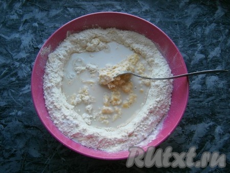 Желтки смешать с мукой, далее постепенно вливать дрожжевую смесь, замешивая ложкой тесто.
