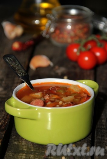 Аппетитный, вкусный, сытный рассольник, приготовленный с колбасой, перловкой и солеными огурцами, подать к столу в горячем виде. 
