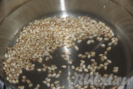 Хорошо промыть перловку проточной водой, а затем выложить в кастрюлю и залить 2,5 литрами холодной воды.
