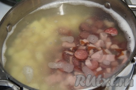 В кастрюлю выложить нарезанную колбасу, довести до кипения, затем, уменьшив огонь, варить 5-7 минут.
