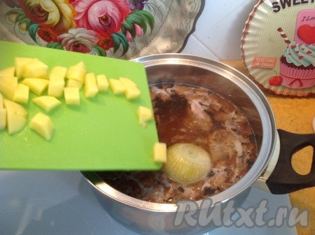 Когда куриное мясо и перловка проварятся минут 40, отправляем в кастрюлю очищенную и нарезанную картошку. Луковицу, которая варилась в бульоне, удаляем. Кусочки курицы достаём, отделяем от костей, мелко нарезаем и возвращаем в кастрюлю.&nbsp;
