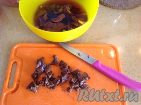 Грибы размокли и слегка увеличились в размере. Нарезаем их и выкладываем в кастрюлю с бульоном и перловкой, варим минут 15.